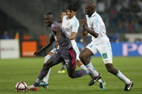 Rennes'Congolese forward Jires Kembo-Ekoko, left,  challenges for the ball with Marseille's French midfielder Alou Diarra , during their League One soccer match, at the Velodrome Stadium, in Marseille, southern France, Saturday, Sept. 10, 2011. (AP Photo/Claude Paris)