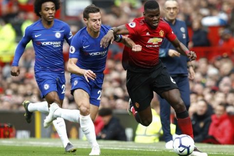 Manchester United's Paul Pogba, right, and Chelsea's Cesar Azpilicueta battle for the ball during their English Premier League soccer match at Old Trafford, Manchester, England, Sunday, April 28, 2019. (Martin Rickett/PA via AP)