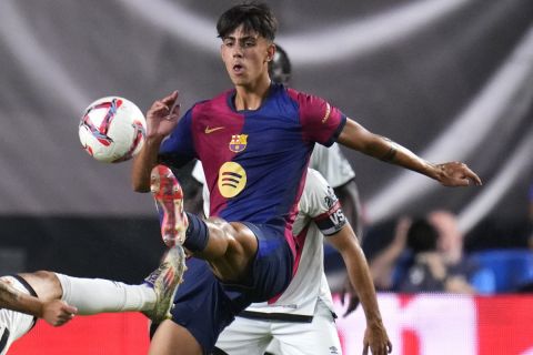 Rayo's Sergio Camello challenges for the ball with Barcelona's Marc Bernal during the Spanish La Liga soccer match between Rayo Vallecano and Barcelona at the Vallecas stadium in Madrid, Spain, Tuesday, Aug. 27, 2024. (AP Photo/Manu Fernandez)