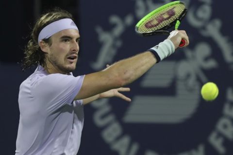 Stefanos Tsitsipas of Greece returns the ball to Serbia's Novak Djokovic during the final match of the Dubai Duty Free Tennis Championship in Dubai, United Arab Emirates, Saturday, Feb. 29, 2020. (AP Photo/Kamran Jebreili)