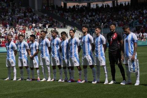 Argentina's starting players listen the national anthems prior to the Men's Group B soccer match between Argentina and Morocco at Geoffroy-Guichard Stadium during the 2024 Summer Olympics, Wednesday, July 24, 2024, in Saint-Etienne, France. (AP Photo/Silvia Izquierdo)