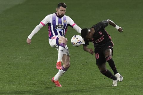 Real Madrid's Vinicius Junior, right, is challenged by Valladolid's Luis Perez during the Spanish La Liga soccer match between Valladolid and Real Madrid at the Jose Zorrila stadium in Valladolid, Spain, Saturday, Feb. 20, 2021. (AP Photo/Alvaro Barrientos)