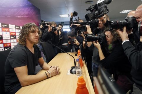 Barcelona's Carles Puyol is surrounded by photographers before announcing his retirement at Ciutat Esportiva Joan Gamper in Sant Joan Despi near Barcelona March 4, 2014. Barcelona captain Puyol will leave the club at the end of the season following a persistent battle with a knee injury, he said on Tuesday.  REUTERS/Gustau Nacarino  (SPAIN - Tags: SPORT SOCCER HEADSHOT) - RTR3G140