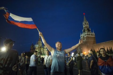 Russia soccer fans celebrate their team victory against Spain in Red Square after the round of 16 match between Spain and Russia at the 2018 soccer World Cup at the Luzhniki Stadium in Moscow, Russia, Sunday, July 1, 2018. Russia shocks Spain at the World Cup, beating the 2010 champion 4-3 in a penalty shootout after a 1-1 draw. (AP Photo/Alexander Zemlianichenko)