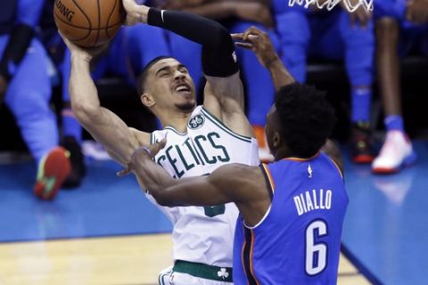 Boston Celtics forward Jayson Tatum (0) shoots as Oklahoma City Thunder guard Hamidou Diallo (6) defends in the first half of an NBA basketball game in Oklahoma City, Thursday, Oct. 25, 2018. (AP Photo/Sue Ogrocki)