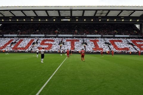 Fans create a crowd mosaic displaying the word: "justice" on the Lower Centenary stand during the English Premier League soccer match between Liverpool and Manchester United at Anfield in Liverpool, England, Sunday Sept. 23, 2012. Liverpool and Manchester United met at Anfield for the Merseyside club's first home match since publication of the report into the Hillsborough disaster. The Hillsborough Independent Panel absolved the club's supporters of any responsibility for the 1989 tragedy, which claimed 96 lives, and criticized South Yorkshire Police. (AP Photo/Clint Hughes)  