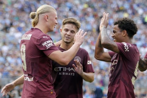 Manchester City's Erling Haaland, left, celebrates after his second-half goal against Chelsea with James McAtee, center, and Oscar Bobb, right, during an FC Series soccer match, Saturday, Aug. 3, 2024, at Ohio Stadium in Columbus, Ohio. (AP Photo/Tom E. Puskar)