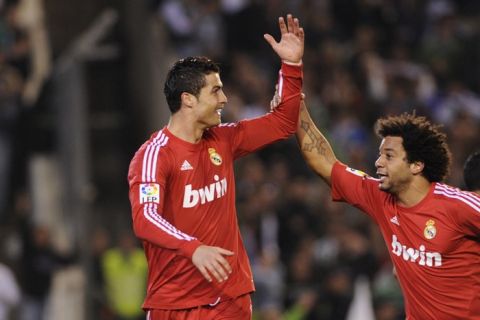 Real Madrid's Portuguese forward Cristiano Ronaldo (R) celebrates with teammate Brazilian defender Marcelo (R) after scoring against Betis during a Spanish League football match Real Madrid vs Betis on March 10, 2012 at Benito Villamarin stadium in Sevilla. AFP PHOTO/ CRISTINA QUICLER (Photo credit should read CRISTINA QUICLER/AFP/Getty Images)