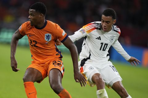 Denzel Dumfries of the Netherlands, left, and Germany's Jamal Musiala fight for the ba;; during the UEFA Nations League soccer match between Netherlands and Germany in Amsterdam, Netherlands, on Tuesday, Sept. 10, 2024. (AP Photo/Peter Dejong)