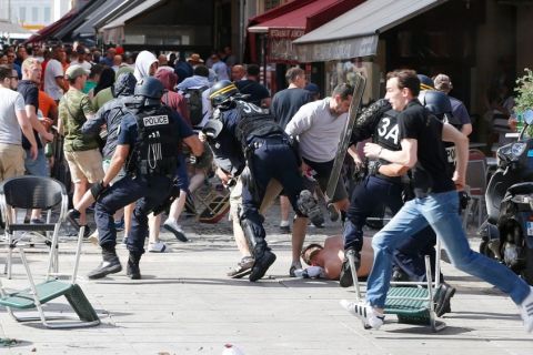 French police officers charge soccer supporters during clashes in downtown Marseille, France, Saturday, June 11, 2016. Riot police have thrown tear gas canisters at soccer fans Saturday in Marseille's Old Port in a third straight day of violence in the city. (AP Photo/Darko Bandic)