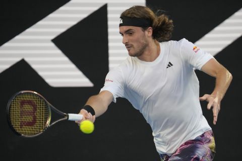 Stefanos Tsitsipas of Greece plays a forehand return to Quentin Halys of France and during their first round match at the Australian Open tennis championship in Melbourne, Australia, Monday, Jan. 16, 2023. (AP Photo/Dita Alangkara)