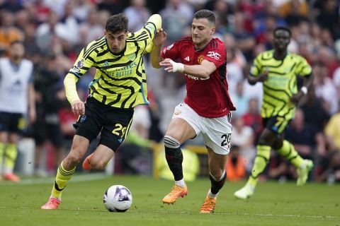 Arsenal's Kai Havertz, left, challenges for the ball with Manchester United's Diogo Dalot during the English Premier League soccer match between Manchester United and Arsenal at the Old Trafford Stadium in Manchester, England, Sunday, May 12, 2024. (AP Photo/Dave Thompson)