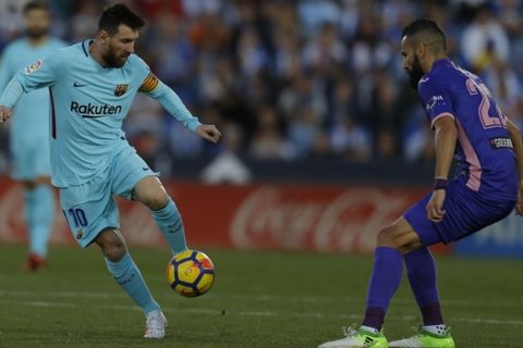 Barcelona's Lionel Messi, left, controls the ball next to Leganes' Dimitrios Siovas during the Spanish La Liga soccer match between Barcelona and Leganes at the Butarque stadium in Madrid, Saturday, Nov 18, 2017. (AP Photo/Francisco Seco)