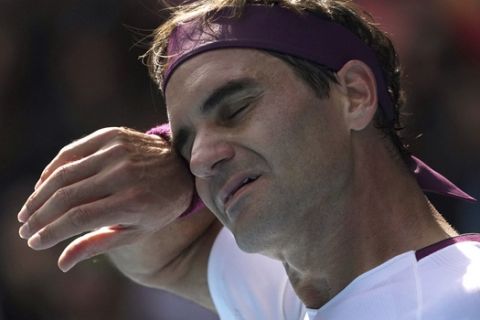 Switzerland's Roger Federer wipes the sweat from his face during his quarterfinal against Tennys Sandgren of the U.S. at the Australian Open tennis championship in Melbourne, Australia, Tuesday, Jan. 28, 2020. (AP Photo/Lee Jin-man)