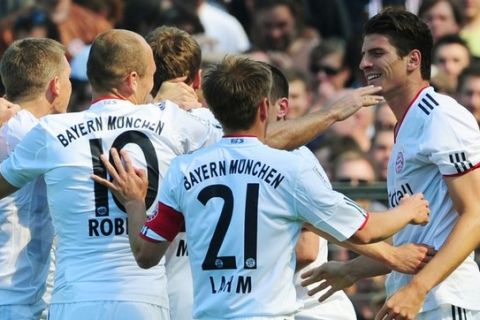 RESTRICTIONS / EMBARGO - ONLINE CLIENTS MAY USE UP TO SIX IMAGES DURING EACH MATCH WITHOUT THE AUTHORISATION OF THE DFL. NO MOBILE USE DURING THE MATCH AND FOR A FURTHER TWO HOURS AFTERWARDS IS PERMITTED WITHOUT THE AUTHORISATION OF THE DFL.Bayern Munich's striker Mario Gomez (R) celebrates scoring with his teammates during the German first division Bundesliga football match FC St. Pauli vs FC Bayern Munich in the northern German city of Hamburg on May 7, 2011.  AFP PHOTO / JOHANNES EISELE (Photo credit should read JOHANNES EISELE/AFP/Getty Images)