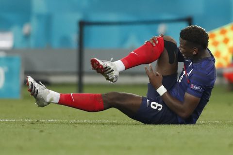 France's Paul Pogba sits on the pitch in pain during the Euro 2020 soccer championship round of 16 match between France and Switzerland at the National Arena stadium in Bucharest, Romania, Monday, June 28, 2021. (Robert Ghement/Pool via AP)