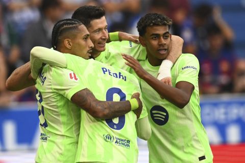 Barcelona's Robert Lewandowski, center, celebrates after scoring his side's 2nd goal against Alaves during a Spanish La Liga soccer match at the Mendizorroza stadium in Vitoria-Gasteiz, Spain, Sunday, Oct. 6, 2024. (AP Photo/Miguel Oses)