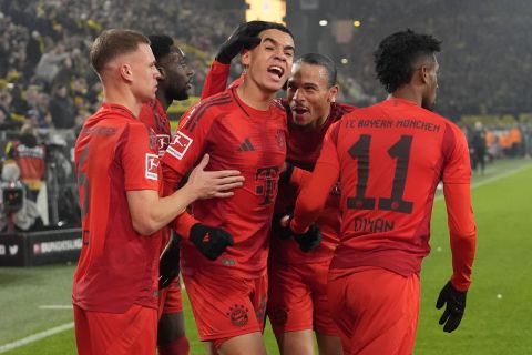 Bayern's Jamal Musiala celebrates with his team after scoring his side's first goal during the German Bundesliga soccer match between Borussia Dortmund and Bayern Munich at the Signal-Iduna Park in Dortmund, Germany, Saturday, Nov. 30, 2024. (AP Photo/Martin Meissner)