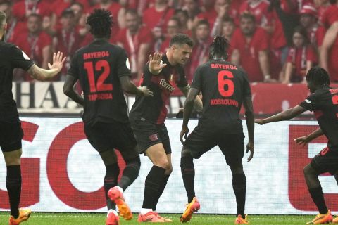 Leverkusen's Granit Xhaka, center, celebrates with teammates after scoring his team's opening goal during the German Soccer Cup final match between 1. FC Kaiserslautern and Bayer Leverkusen at the Olympic Stadium in Berlin, Germany, Saturday, 25 May, 2024. (AP Photo /Mathias Schrader)