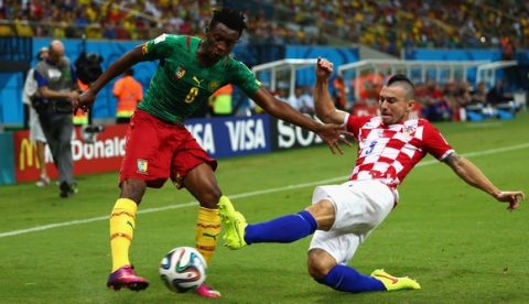 MANAUS, BRAZIL - JUNE 18: Benjamin Moukandjo of Cameroon is tackled by Danijel Pranjic of Croatia during the 2014 FIFA World Cup Brazil Group A match between Cameroon and Croatia at Arena Amazonia on June 18, 2014 in Manaus, Brazil.  (Photo by Clive Brunskill/Getty Images)