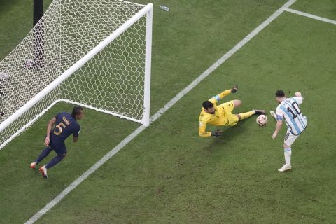 Argentina's Lionel Messi, right, scores his side's first goal passing France's goalkeeper Hugo Lloris during the World Cup final soccer match between Argentina and France at the Lusail Stadium in Lusail, Qatar, Sunday, Dec. 18, 2022. (AP Photo/Thanassis Stavrakis)