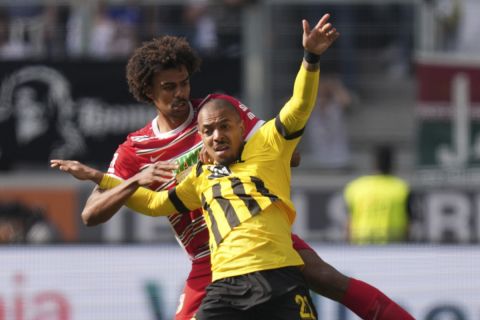 Dortmund's Donyell Malen, right, challenges for the ball with Augsburg's Renato Veiga during the German Bundesliga soccer match between FC Augsburg and Borussia Dortmund at the WWK Arena in Augsburg, Germany, Sunday, May 21, 2023. (AP Photo/Matthias Schrader)