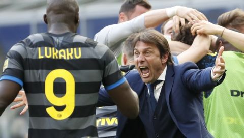 Inter Milan's head coach Antonio Conte and players celebrate after Matteo Darmian scored during the Serie A soccer match between Inter Milan and Hellas Verona, at the San Siro stadium in Milan, Italy, Sunday, April 25, 2021. (AP Photo/Antonio Calanni)