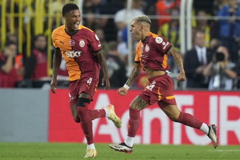 Galatasaray's Lucas Torreira, right, celebrates the opening goal during the Turkish Super Lig soccer match between Fenerbahce and Galatasaray at the Sukru Saracoglu in Istanbul, Turkey, Saturday, Sept. 21, 2024. (AP Photo/Francisco Seco)