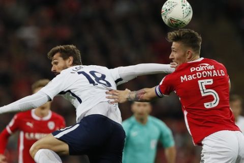 Tottenham's Fernando Llorente, left, vies for the ball with Barnsley's Angus MacDonald during the English League Cup soccer match between Tottenham Hotspur and Barnsley at Wembley stadium in London, Tuesday, Sept. 19, 2017. (AP Photo/Kirsty Wigglesworth)