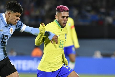 Brazil's Yan Couto, right, and Uruguay's Maximiliano Araujo battle for the ball during a qualifying soccer match for the FIFA World Cup 2026 at Centenario stadium in Montevideo, Uruguay, Tuesday, Oct. 17, 2023. (AP Photo/Santiago Mazzarovich)