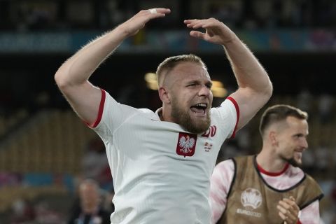 Poland's Tymoteusz Puchacz, left, celebrates with teammates after the Euro 2020 soccer championship group E match between Spain and Poland at La Cartuja stadium in Seville, Spain, Saturday, June 19, 2021. (AP Photo/Thanassis Stavrakis, Pool)