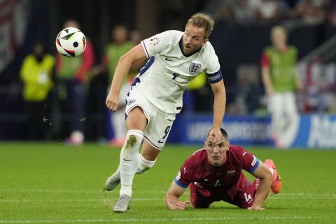 England's Harry Kane is challenged by Serbia's Nikola Milenkovic during a Group C match between Serbia and England at the Euro 2024 soccer tournament in Gelsenkirchen, Germany, Sunday, June 16, 2024. (AP Photo/Andreea Alexandru)