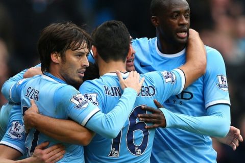 MANCHESTER, ENGLAND - DECEMBER 14:  David Silva, Pablo Zabaleta, Yaya Toure, Sergio Aguero of Manchester City celebrate with Alvaro Negredo of Manchester City after he scored their second goal during the Barclays Premier League match between Manchester City and Arsenal at Etihad Stadium on December 14, 2013 in Manchester, England.  (Photo by Clive Brunskill/Getty Images)