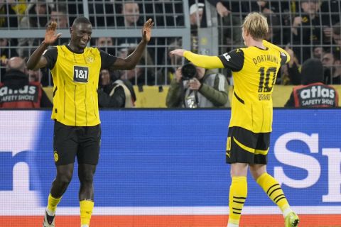 Dortmund's Serhou Guirassy, left, celebrates after he scored during the German Bundesliga soccer match between Borussia Dortmund and RB Leipzig at the Signal-Iduna Park in Dortmund, Germany, Saturday, Nov. 2, 2024. (AP Photo/Martin Meissner)