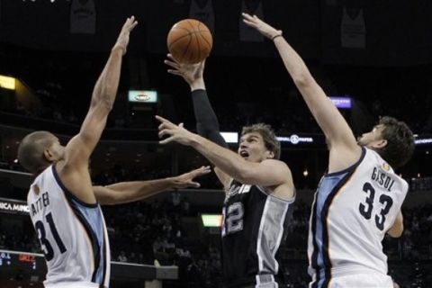 San Antonio Spurs forward Tiago Splitter (22), of Brazil, goes to the basket against Memphis Grizzlies forward Shane Battier (31) and center Marc Gasol (33), of Spain, during the first half of an NBA basketball game in Memphis, Tenn., Tuesday, March 1, 2011. (AP Photo/Lance Murphey)