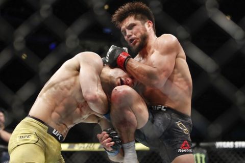 Henry Cejudo, right, kicks Marlon Moraes during their bantamweight title mixed martial arts bout at UFC 238, Saturday, June 8, 2019, in Chicago. (AP Photo/Kamil Krzaczynski)