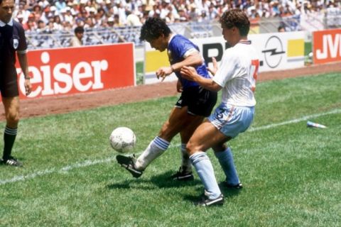 (L-R) Argentina's Diego Maradona juggles the ball as he shields it from England's Kenny Sansom