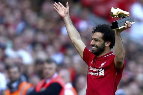 Liverpool's Mohamed Salah lifts up his golden boot award after the English Premier League soccer match against Brighton & Hove Albion at Anfield, Liverpool, England, Sunday, May 13, 2018. (Dave Thompson/PA via AP)