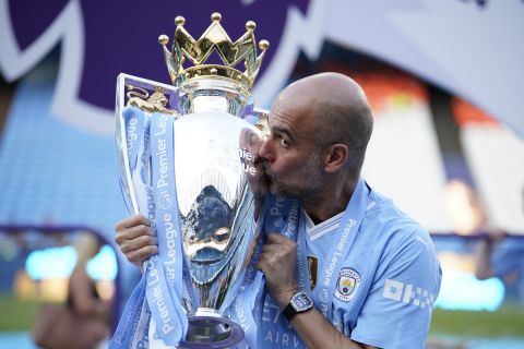 Manchester City's head coach Pep Guardiola celebrates with the Premier League trophy after the English Premier League soccer match between Manchester City and West Ham United at the Etihad Stadium in Manchester, England, Sunday, May 19, 2024. Manchester City clinched the English Premier League on Sunday after beating West Ham in their last match of the season. (AP Photo/Dave Thompson)