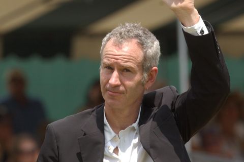 Tennis legend John McEnroe acknowledges the crowd during the parade of hall of famers at the International Tennis Hall of Fame's 50th anniversary celebration in Newport.