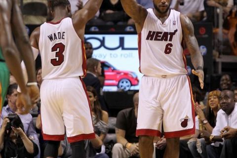 MIAMI, FL - APRIL 10:  LeBron James #6 and Dwyane Wade #3 of the Miami Heat high five during a game against the Boston Celtics at American Airlines Arena on April 10, 2011 in Miami, Florida. NOTE TO USER: User expressly acknowledges and agrees that, by downloading and/or using this Photograph, User is consenting to the terms and conditions of the Getty Images License Agreement.  (Photo by Mike Ehrmann/Getty Images)