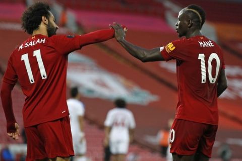 Liverpool's Sadio Mane, right, celebrates scoring his side's fourth goal with Mo Salah during the English Premier League soccer match between Liverpool and Crystal Palace at Anfield Stadium in Liverpool, England, Wednesday, June 24, 2020. (Phil Noble/Pool via AP)