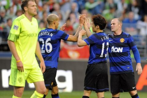 SEATTLE, WA - JULY 20: Gabriel Obertan #26, Ji-Sung Park #13 and Wayne Rooney #10 of Manchester United celebrate after Rooney scored a goal during the second half of the game against the Seattle Sounders FC at CenturyLink Field on July 20, 2011 in Seattle, Washington. Manchester United won the game 7-0. (Photo by Steve Dykes/Getty Images)