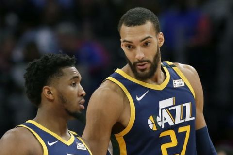 En imagen de archivo del sábado 7 de marzo de 2020, el base Donovan Mitchell, izquierda, del Jazz de Utah, dialoga con su compañero Rudy Gobert en el partido frente a los Pistons, en Detroit. El 18 de marzo del 2020, el comisionado Adam Silver dijo que consideran varios escenarios para enfrentar la suspensión de jugadores, inlcuyendo aislar a varios jugadores para que se enfrenten. (AP Foto/Duane Burleson, archivo)