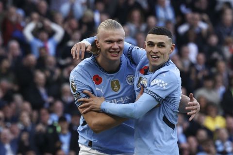 Manchester City's Erling Haaland, second right, celebrates with Manchester City's Phil Foden after scoring his side's opening goal during the English Premier League soccer match between Manchester City and Southampton at the Etihad Stadium in Manchester, England, Saturday, Oct. 26, 2024. (AP Photo/Darren Staples)