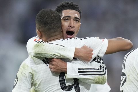 Real Madrid's Jude Bellingham, right, hugs to congratulate teammate Kylian Mbappe on scoring his side's second goal during the Spanish La Liga soccer match between Real Madrid and Getafe at the Santiago Bernabeu Stadium in Madrid, Spain, Sunday, Dec. 1, 2024. (AP Photo/Bernat Armangue)