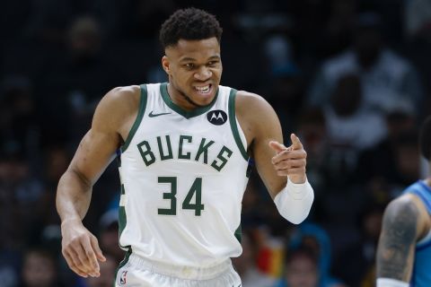 Milwaukee Bucks forward Giannis Antetokounmpo (34) points to a teammate after being fouled as Charlotte Hornets forward Miles Bridges (0) looks on during the first half of an NBA basketball game in Charlotte, N.C., Thursday, Feb. 29, 2024. (AP Photo/Nell Redmond)