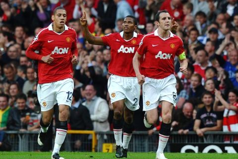 Manchester United's Ecuador midfielder Antonio Valencia (C) celebrates with teammates Irish defender John O'Shea (R) and English defender Chris Smalling after scoring the opening goal during the UEFA Champions League semi-final second leg football match between Manchester United and FC Schalke at Old Trafford in Manchester, north-west England on May 4, 2011. AFP PHOTO/PAUL ELLIS (Photo credit should read PAUL ELLIS/AFP/Getty Images)