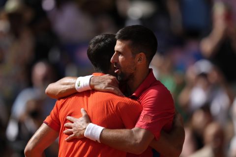 Serbia's Novak Djokovic, right, hugs Spain's Carlos Alcaraz after the men's singles tennis final at the Roland Garros stadium during the 2024 Summer Olympics, Sunday, Aug. 4, 2024, in Paris, France. Djokovic has won his first Olympic gold medal by beating Carlos Alcaraz 7-6 (3), 7-6 (2) in the 2024 Games men's tennis singles final. (AP Photo/Manu Fernandez)