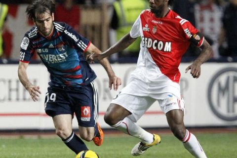 Cesar Delgado (L) of Olympique Lyon challenges Julio Nkoulou of AS Monaco during their French Ligue 1 soccer match at the Louis II stadium in Monaco, May 29, 2011.    REUTERS/Robert Pratta (MONACO - Tags: SPORT SOCCER)